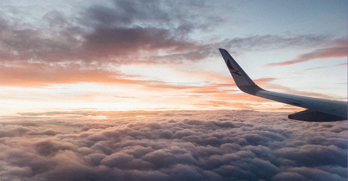 photo showing a view of an airplane tail over clouds