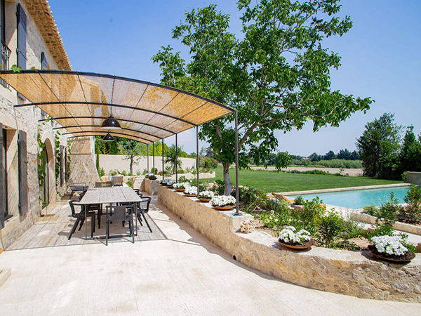 photo of a poolside patio of a villa in France, with a large table for dining outdoors, from Villas of Distinction 